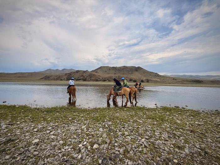 Crossing the river on horseback